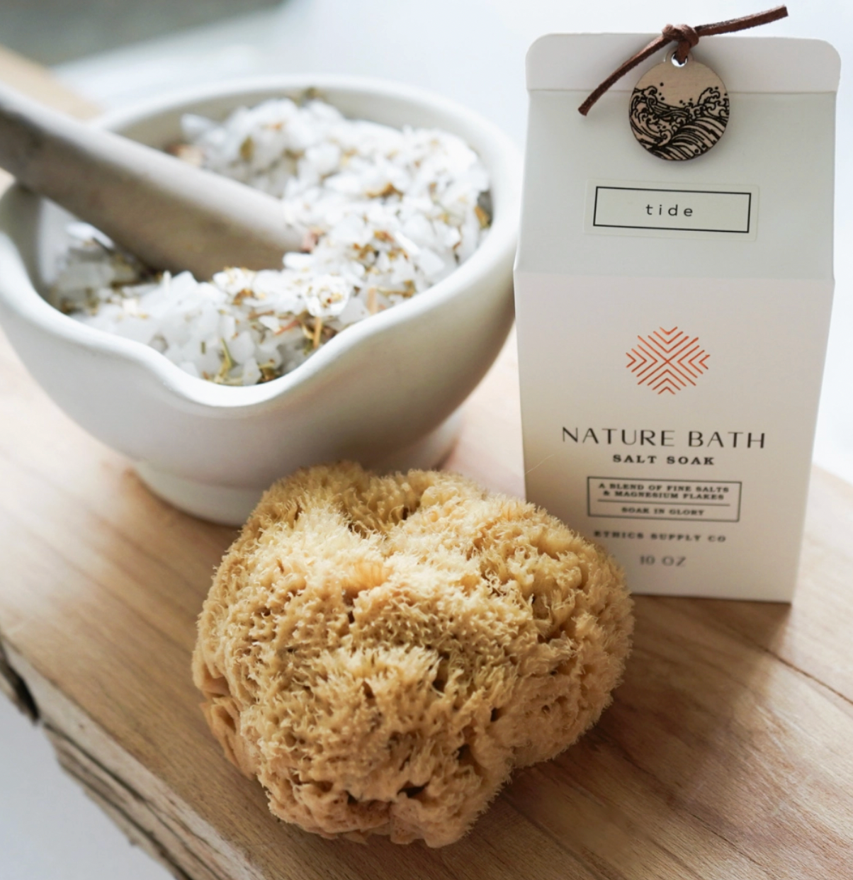 Nature Bath salt soap with a loofah and bowl of bath salts on a wooden surface