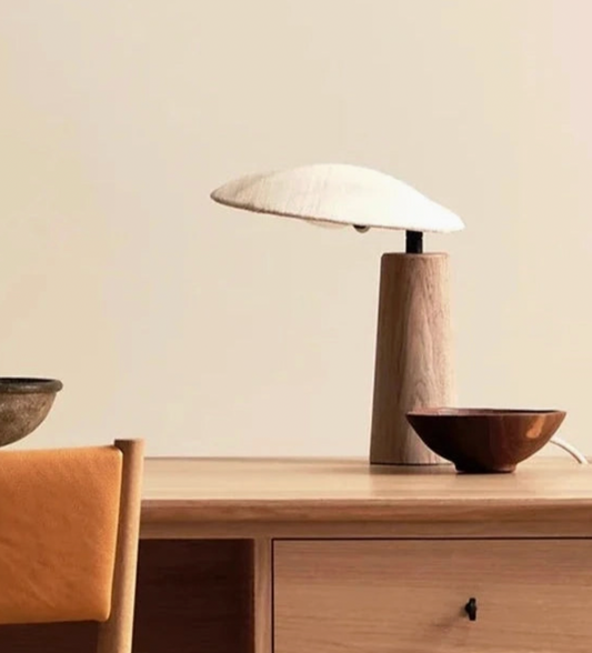 Wooden desk with a lamp and bowls on a neutral background